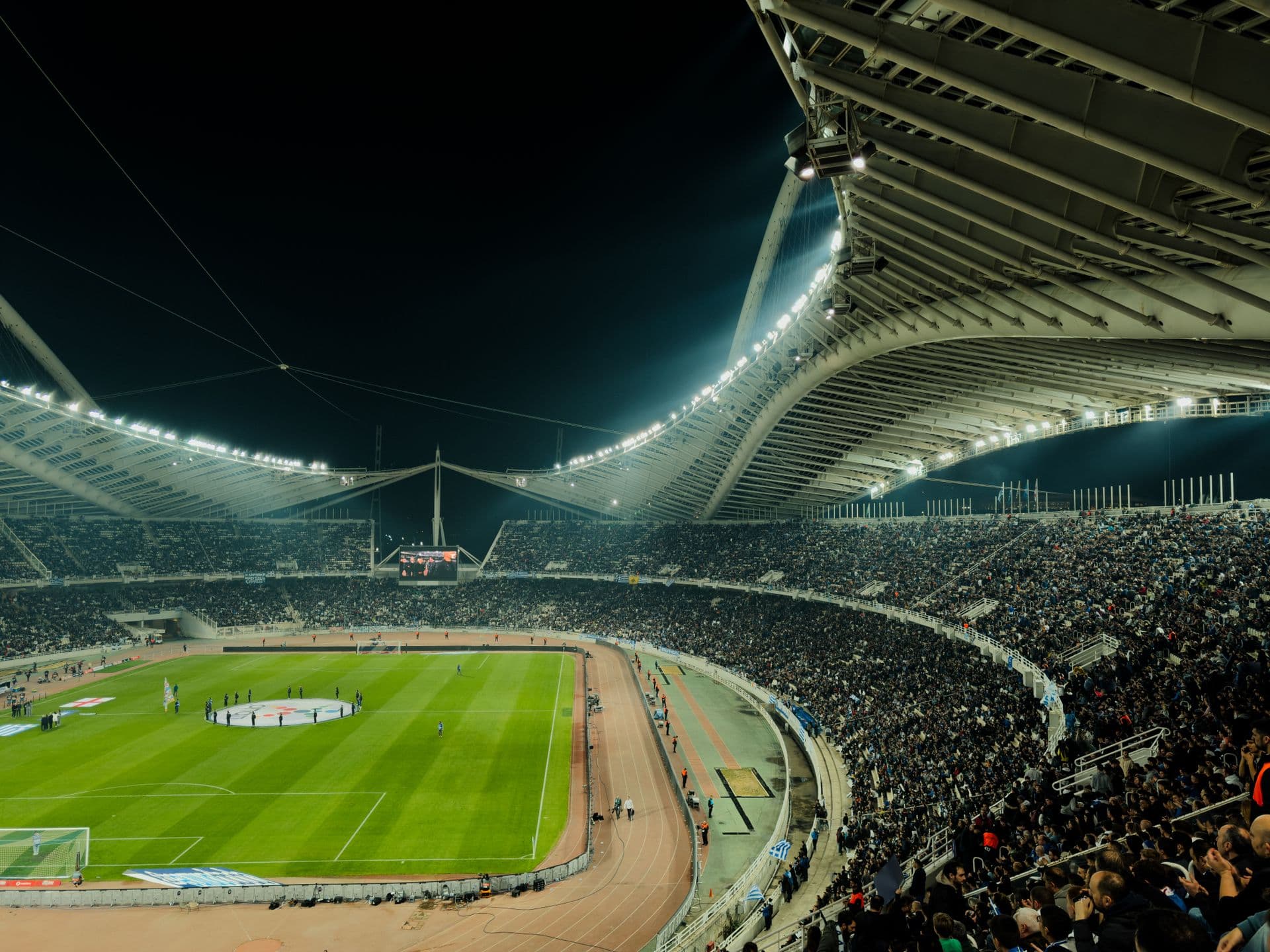 Illuminated stadium at night with crowd